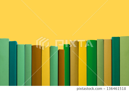 Books are arranged by color on a yellow background in a study Books are arranged by color on a yellow background in a study 136461518