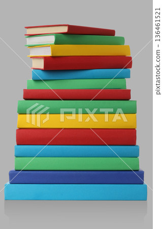 Colorful books stacked vertically on a plain backdrop Colorful books stacked vertically on a plain backdrop 136461521