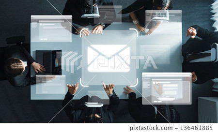Teamwork in Modern Office Setting with Digital Interface and Email Symbol Overhead View of Business Meeting Focused on Technology and Collaboration. Raster 136461885