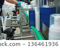 Bottles without labels on the conveyor of a cosmetics factory. Manufacture of cosmetics and skin care products. A white plastic bottle. 136461936
