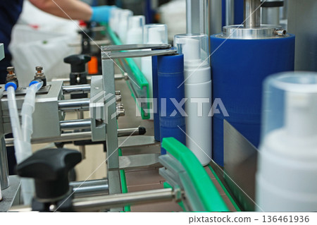 Bottles without labels on the conveyor of a cosmetics factory. Manufacture of cosmetics and skin care products. A white plastic bottle. Bottles without labels on the conveyor of a cosmetics factory. Manufacture of cosmetics and skin care products. A white plastic bottle. 136461936
