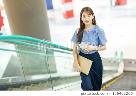 Business woman riding escalator 136462266