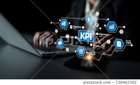 Business Professional Analyzing Key Performance Indicators with Laptop and Smart Device, Visualizing Goals and Metrics for Effective Strategy Development. Tessel Business Professional Analyzing Key Performance Indicators with Laptop and Smart Device, Visualizing Goals and Metrics for Effective Strategy Development. Tessel 136462302