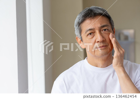A middle-aged man looking in the mirror and worrying A middle-aged man looking in the mirror and worrying 136462454