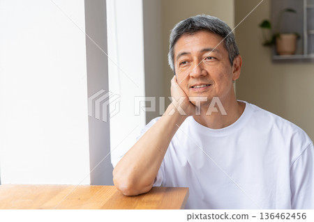 Smiling senior man resting his chin on his hand 136462456