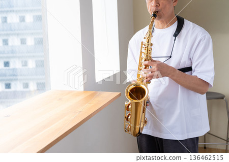 Senior man playing the saxophone 136462515