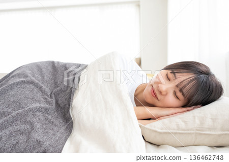 一個睡在床上的年輕女人 136462748
