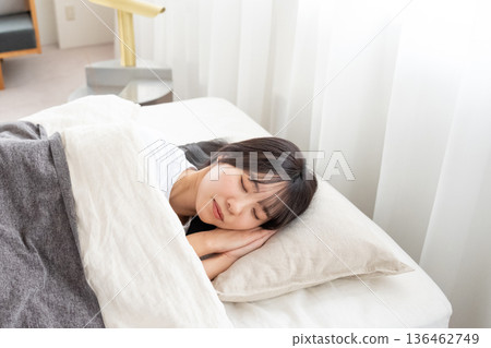 一個睡在床上的年輕女人 136462749