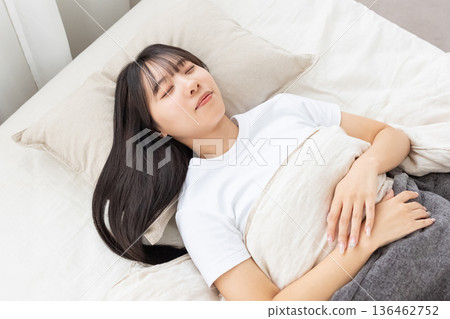 A young woman sleeping in bed 136462752