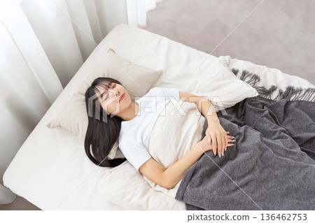 A young woman sleeping in bed 136462753