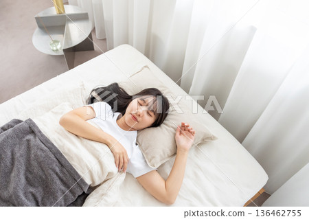 A young woman sleeping in bed A young woman sleeping in bed 136462755