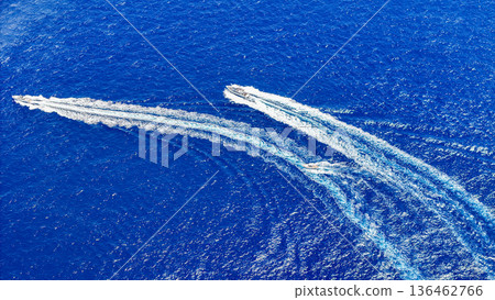 Thrilling boat race across the vibrant blue ocean waves on a sunny day 136462766