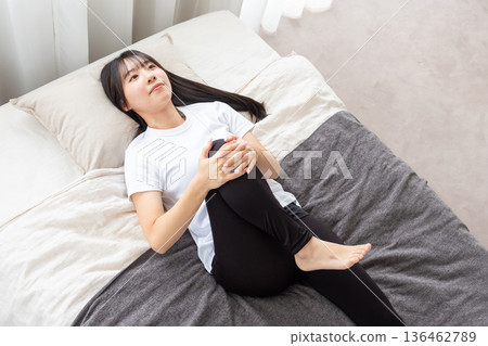 婦女在床上伸展 婦女在床上伸展 136462789