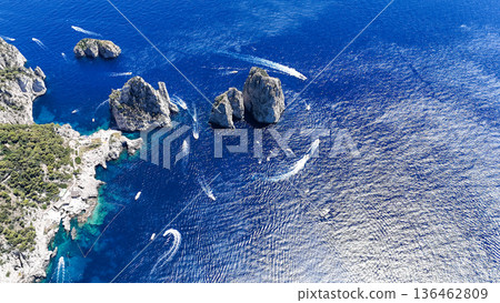 Breathtaking view of azure waters and rocky formations near a coastal paradise filled with boats sailing beneath a clear sky 136462809