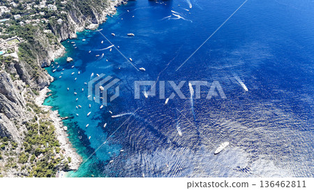 Breathtaking view of boats gliding over emerald waters in the stunning coastline of Capri on a sunlit afternoon Breathtaking view of boats gliding over emerald waters in the stunning coastline of Capri on a sunlit afternoon 136462811