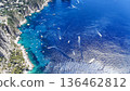 Vibrant blue waters of Capri invite exploration by boats under the sun in a stunning coastal landscape 136462812