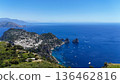 Breathtaking coastal view from a high vantage point overlooking the azure waters of Capri on a sunny day, showcasing boats and rocky formations 136462816