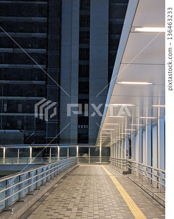 Pedestrian walkway at night in the city, pedestrian deck and skyscraper view Pedestrian walkway at night in the city, pedestrian deck and skyscraper view 136463233