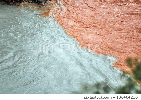 Confluence of two rivers with distinct colors. Natural phenomenon where river waters merge. Concept for contrast and natures beauty. Confluence of two rivers with distinct colors. Natural phenomenon where river waters merge. Concept for contrast and natures beauty. 136464210