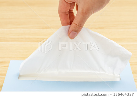 一位女士的右手拿著一張紙巾。 136464357