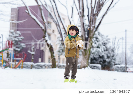 一個6歲男孩在雪地公園玩耍 136464367