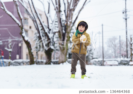 A 6-year-old boy playing in a snowy park 136464368