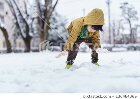 A 6-year-old boy playing in a snowy park 136464369