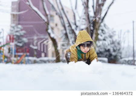 A 6-year-old boy playing in a snowy park 136464372