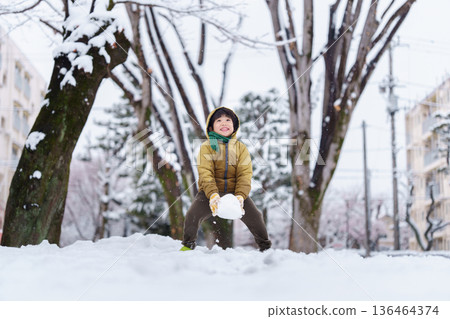 一個6歲男孩在雪地公園玩耍 136464374
