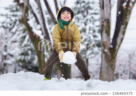 一個6歲男孩在雪地公園玩耍 136464375