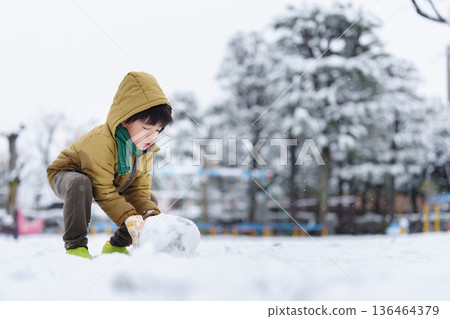 一個6歲男孩在雪地公園玩耍 136464379