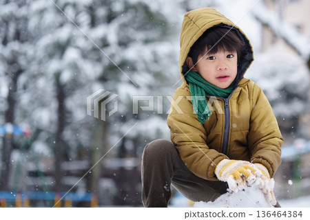A 6-year-old boy playing in a snowy park 136464384