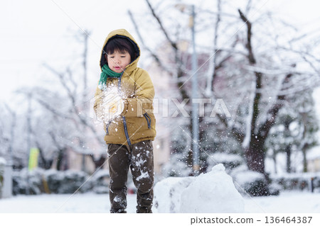 A 6-year-old boy playing in a snowy park 136464387