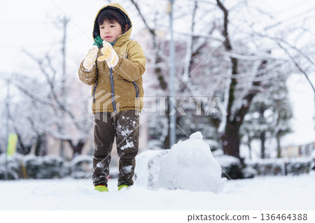 A 6-year-old boy playing in a snowy park A 6-year-old boy playing in a snowy park 136464388