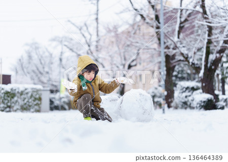 一個6歲男孩在雪地公園玩耍 136464389