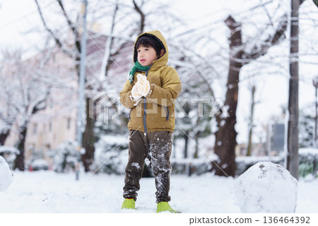 一個6歲男孩在雪地公園玩耍 136464392