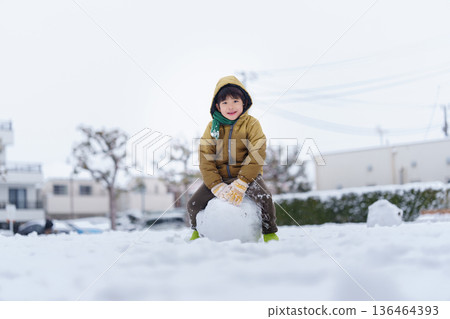 一個6歲男孩在雪地公園玩耍 136464393