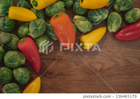 Colorful combination of brussel sprouts and bell peppers on a wood background Colorful combination of brussel sprouts and bell peppers on a wood background 136465179
