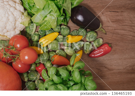 Fresh, colorful vegetables and greens on a wooden background with copy space Fresh, colorful vegetables and greens on a wooden background with copy space 136465193