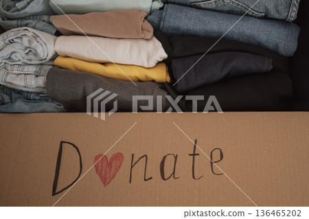 Box filled with neatly folded clothes ready for donation at a local charity for those in need Box filled with neatly folded clothes ready for donation at a local charity for those in need 136465202