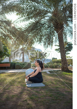 Pregnant Woman Practicing Yoga Outdoors In A Peaceful Natural Setting 136465438