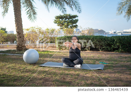 Pregnant Woman Practicing Yoga Outdoors In A Peaceful Natural Setting 136465439