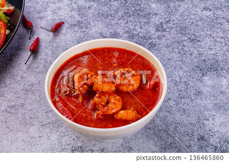Spicy shrimp soup Red Thai Curry with prawns and vegetables in a vibrant red broth. Asian cuisine concept. Spicy shrimp soup Red Thai Curry with prawns and vegetables in a vibrant red broth. Asian cuisine concept. 136465860