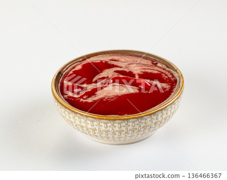Bowl of red tomato ketchup or sauce isolated on a white background. Bowl of red tomato ketchup or sauce isolated on a white background. 136466367