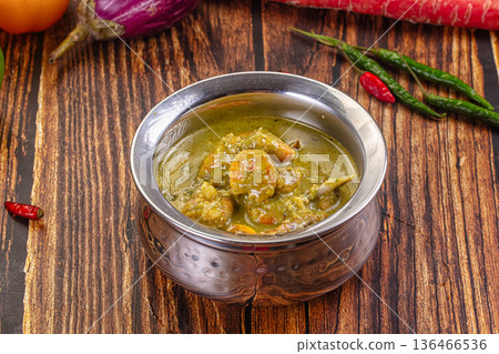 Thai green curry with shrimp and broccoli in a bowl, surrounded by fresh ingredients on a wooden table Thai green curry with shrimp and broccoli in a bowl, surrounded by fresh ingredients on a wooden table 136466536
