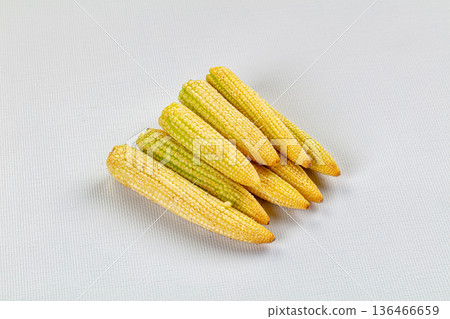 Pile of fresh raw baby corn on a textured background 136466659
