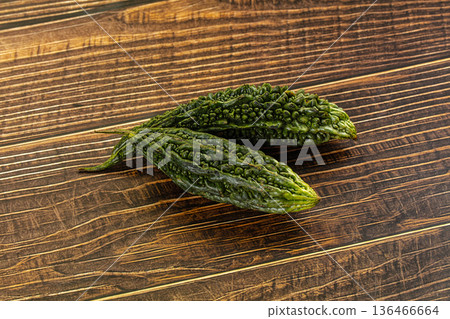 Whole bitter gourds on a dark textured slate background with copy space Whole bitter gourds on a dark textured slate background with copy space 136466664