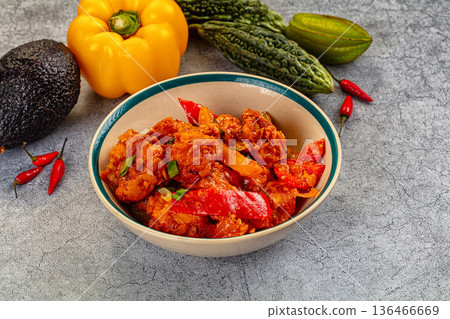 Spicy chicken curry in a bowl surrounded by fresh bell pepper, avocado, and bitter melon Spicy chicken curry in a bowl surrounded by fresh bell pepper, avocado, and bitter melon 136466669