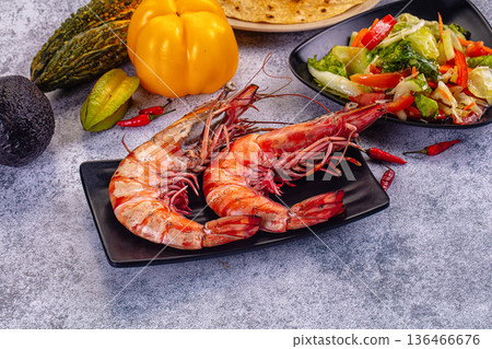 Grilled giant red prawns in a pan with fresh avocado, bell pepper, and salad on a stone table Grilled giant red prawns in a pan with fresh avocado, bell pepper, and salad on a stone table 136466676