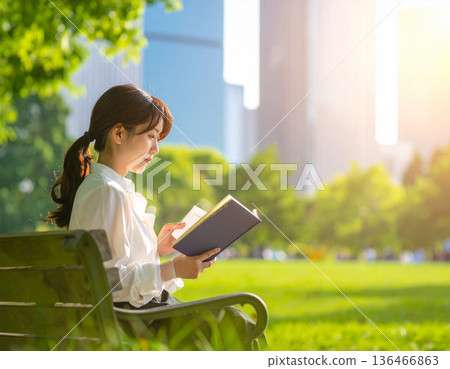 Fresh green season, urban buildings, woman reading in park 136466863
